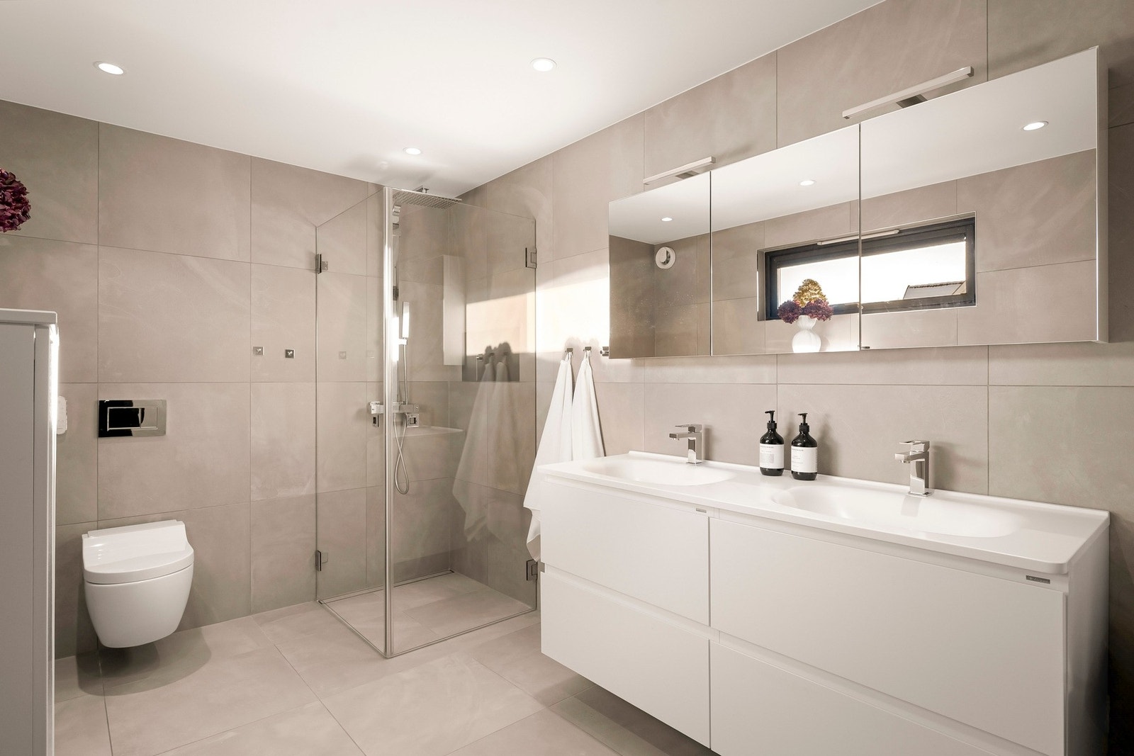 Et praktisk og stilrent, flislagt bad med behagelige varmekabler i gulvet. Galleribilde