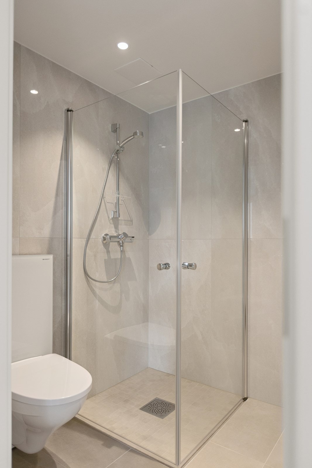 Dusjhjørne med svingdører, håndholdt dusj og termostatstyrt blandebatteri. Galleribilde