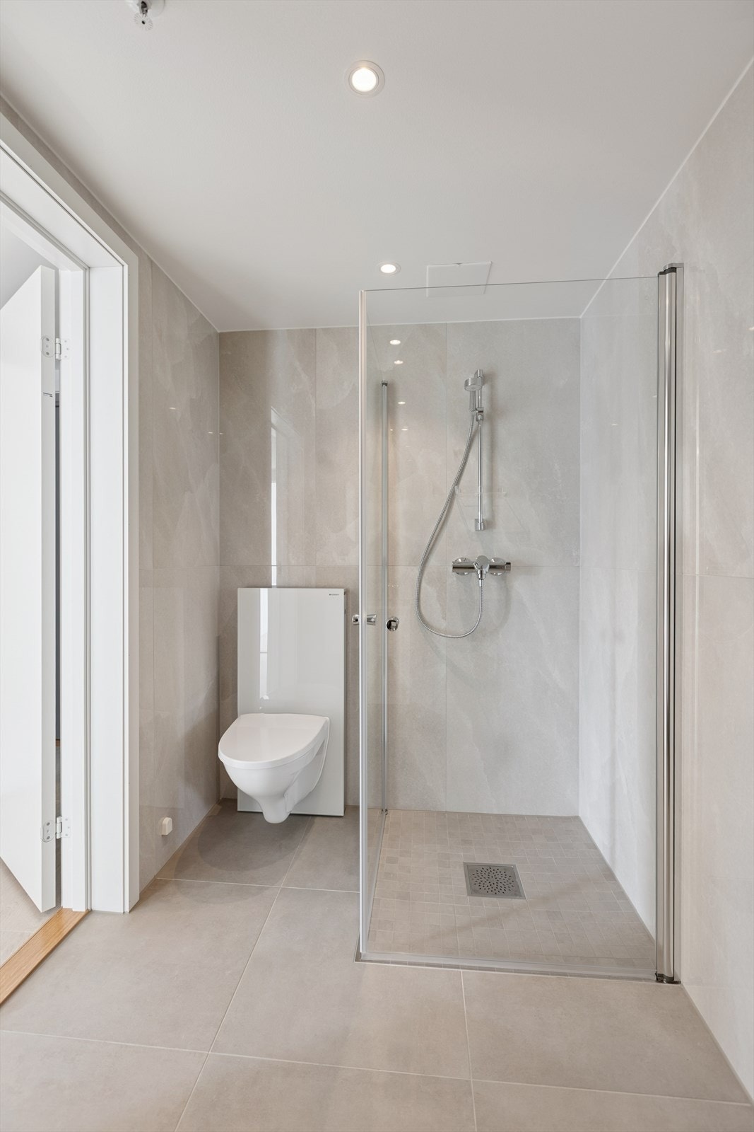 Downlights i himling, dusjhjørne og veggmontert toalett. Galleribilde