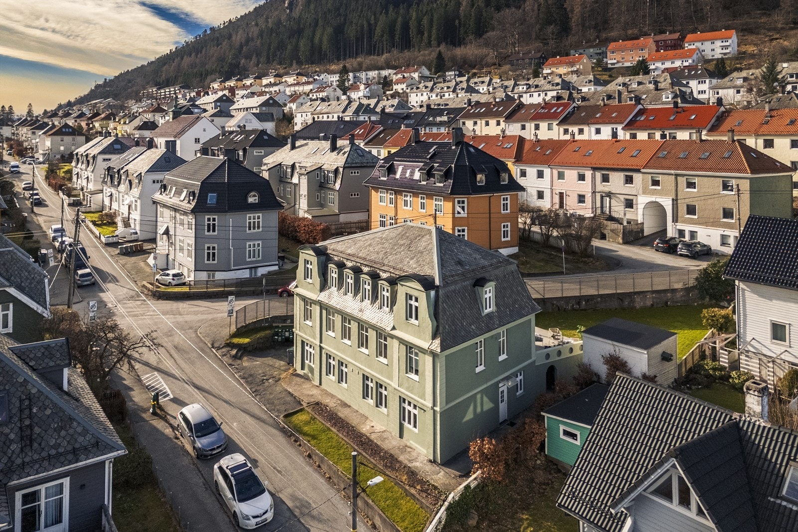 Bygget har et klassisk og velholdt uttrykk med en harmonisk fasade og tydelig karakter. Huset er malt i en nydelig grønn farge og fikk nytt strøk sommeren 2024, i tillegg til nye beslag på taket. Fotograf utebilder: Mood Foto Galleribilde