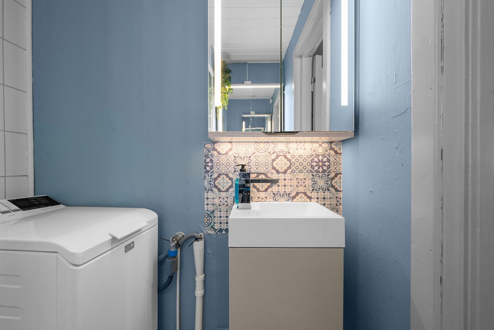 Moderne baderomsinnredning med servant og speilskap med integrert belysning. Galleribilde