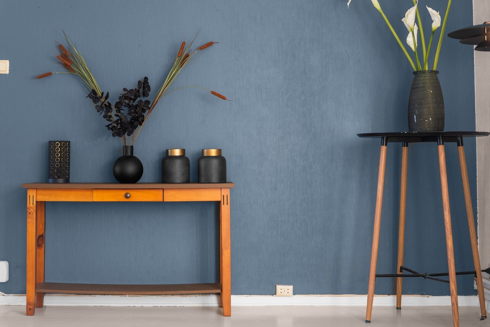 En fondvegg i en dyp blåtone gir stuen karakter og dybde. Galleribilde