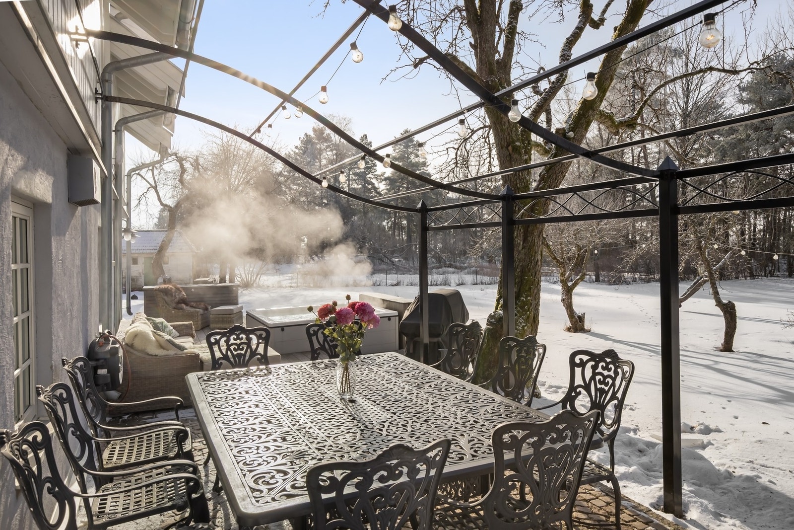 Steinbelagt uteplass med pergola og terrasse med jacuzzi Galleribilde