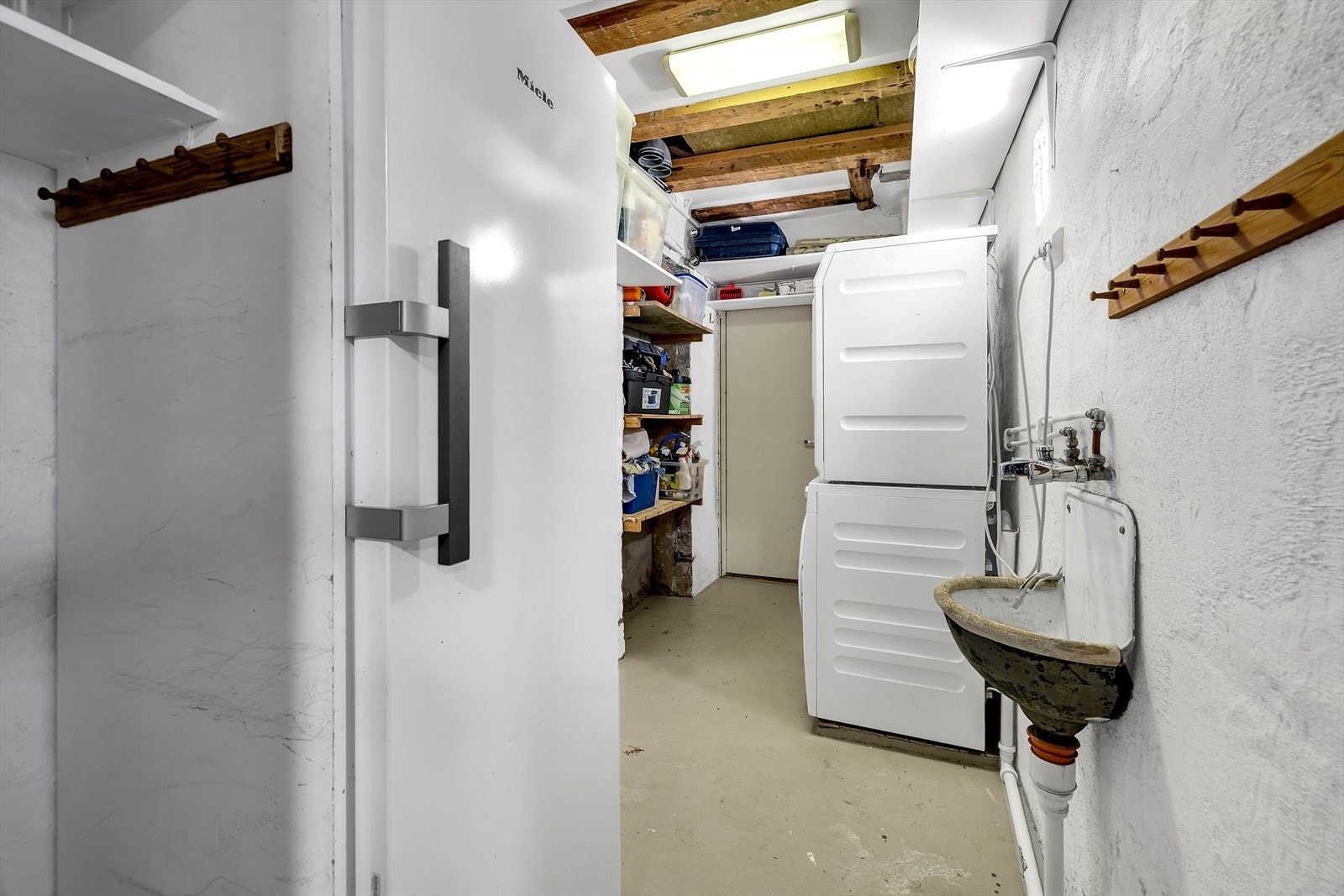 Praktisk bod med hyller, ekstra fryseskap og opplegg for vaskemaskin og tørketrommel. Galleribilde