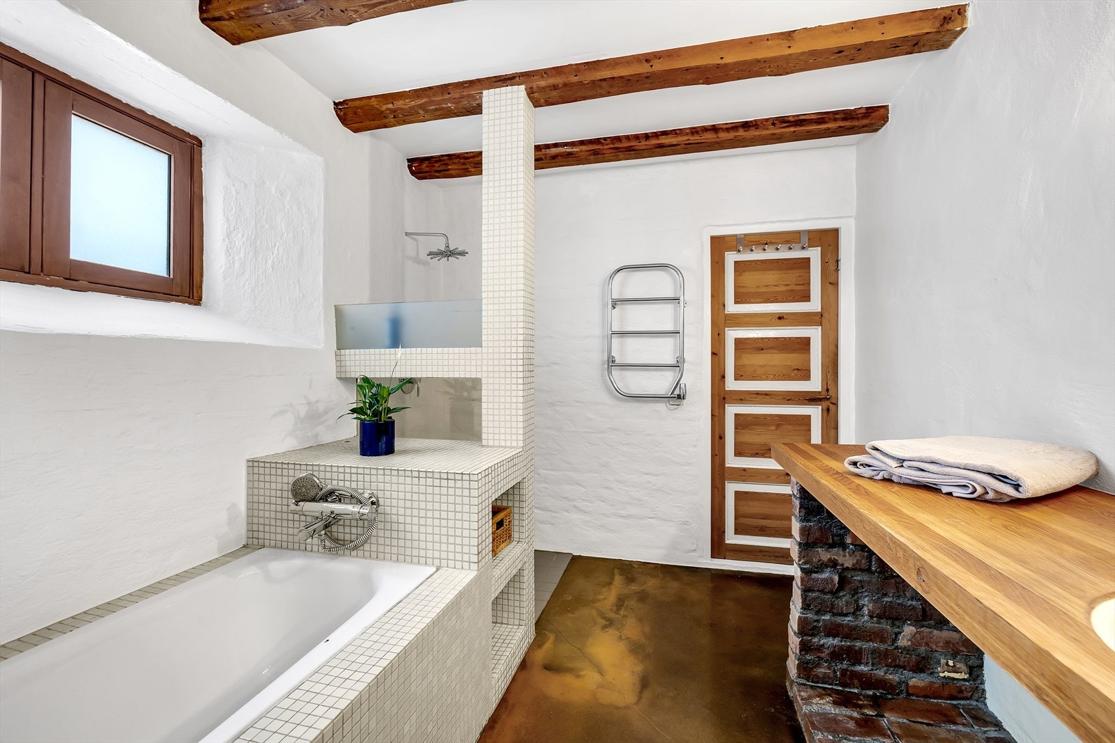 Innredningen består av servant på heltre benkeplate med underskap og speilskap med belysning over. Ellers er det installasjoner som innfliset badekar, wc og dusjnisje. Galleribilde