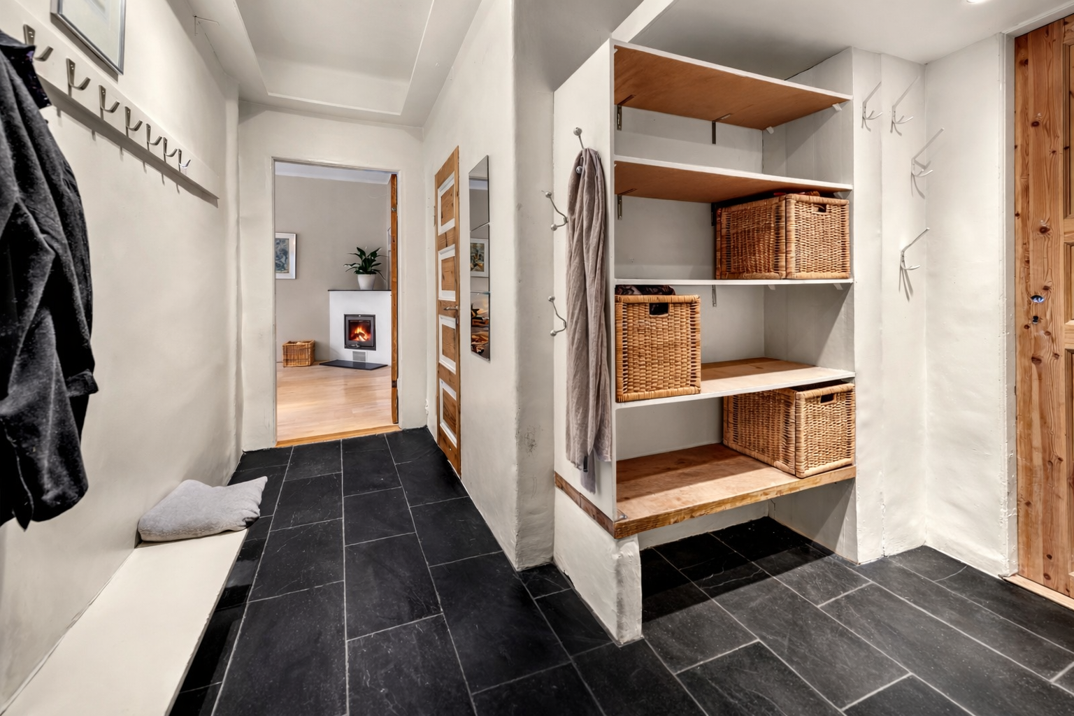 Flislagt gulv gir en praktisk og robust entréløsning. Plassbygd garderobe gir effektiv oppbevaring. Galleribilde