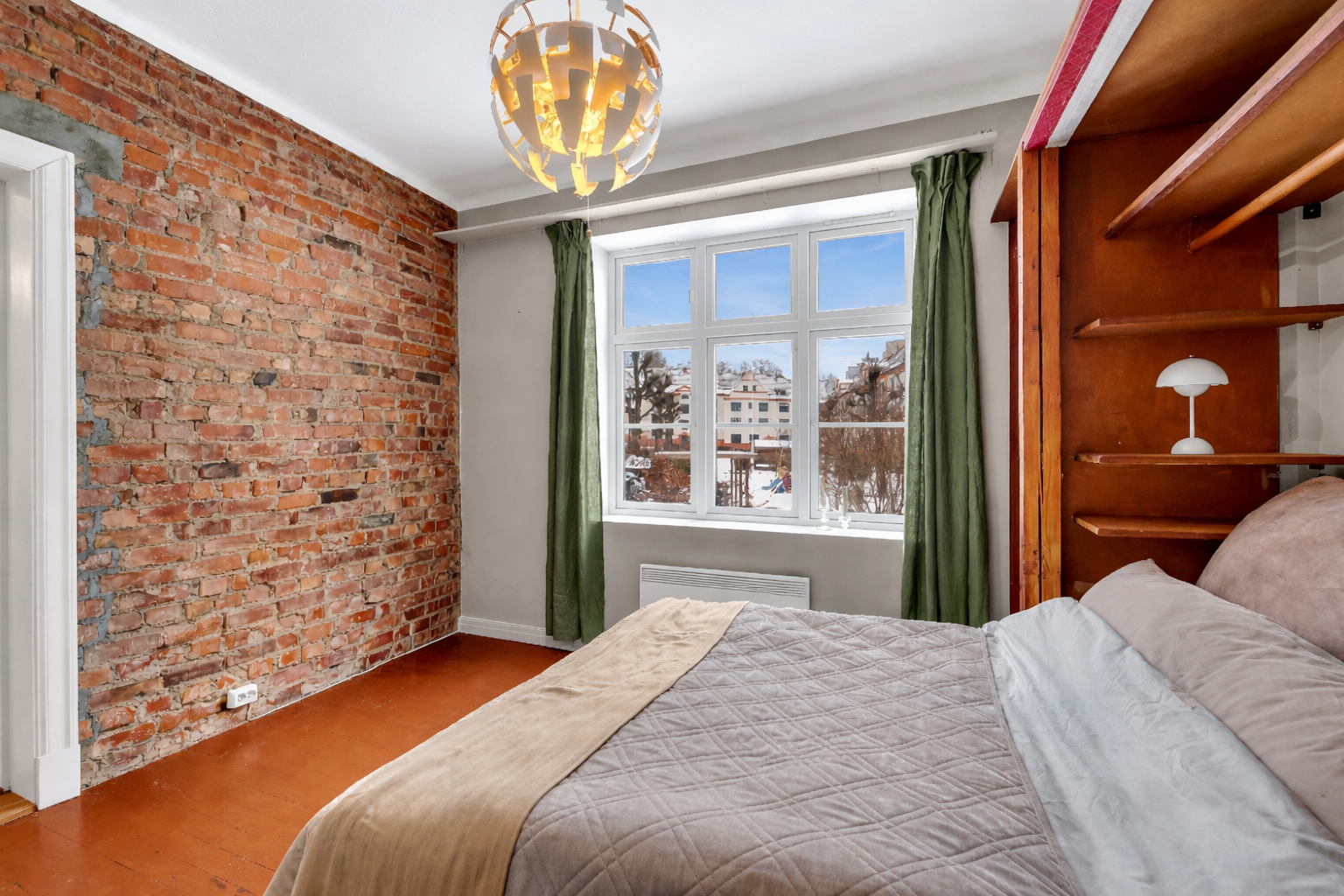 Eksponert teglsteinsvegg gir rommet et rustikt preg, kombinert med malte flater og plassbygd innredning. Galleribilde