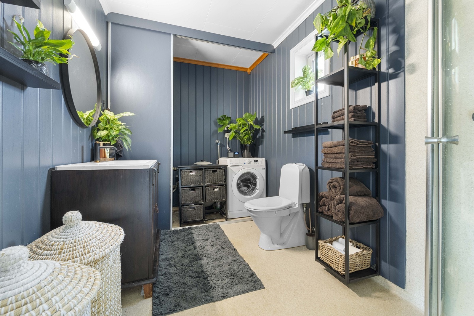 Pent baderom med vaskemaskin bak skyvedørs garderober som gjør det mulig å holde det avskilt om ønskelig Galleribilde