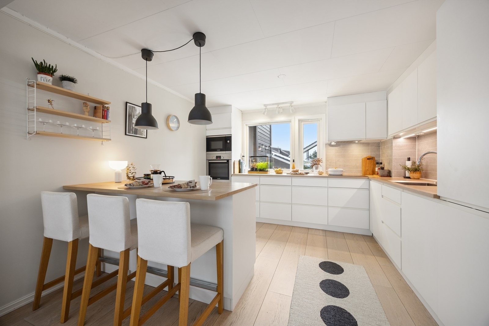 Smakfullt kjøkken fra 2018 med hvite, glatte fronter og laminert benkeplate, utstyrt med kjøkkenkran og oppvaskkum. Galleribilde