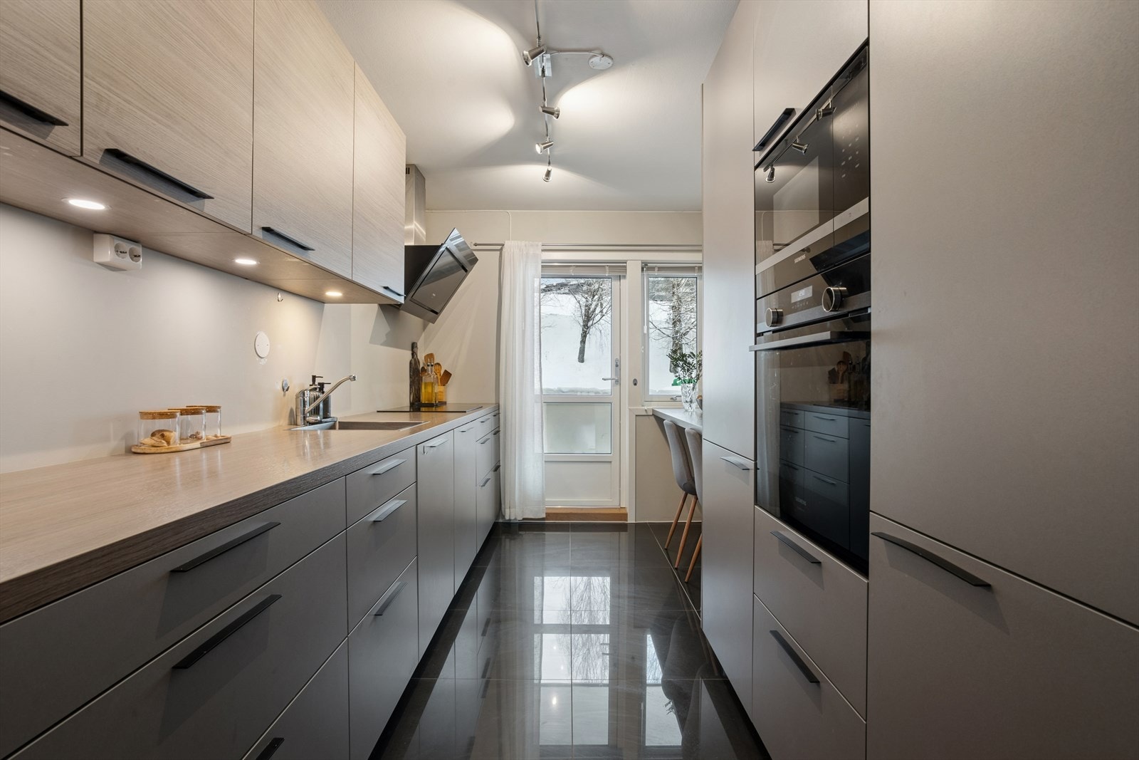 Kjøkkenet fra 2017 er velutstyrt med integrerte hvitevarer og rikelig med skapplass. Galleribilde