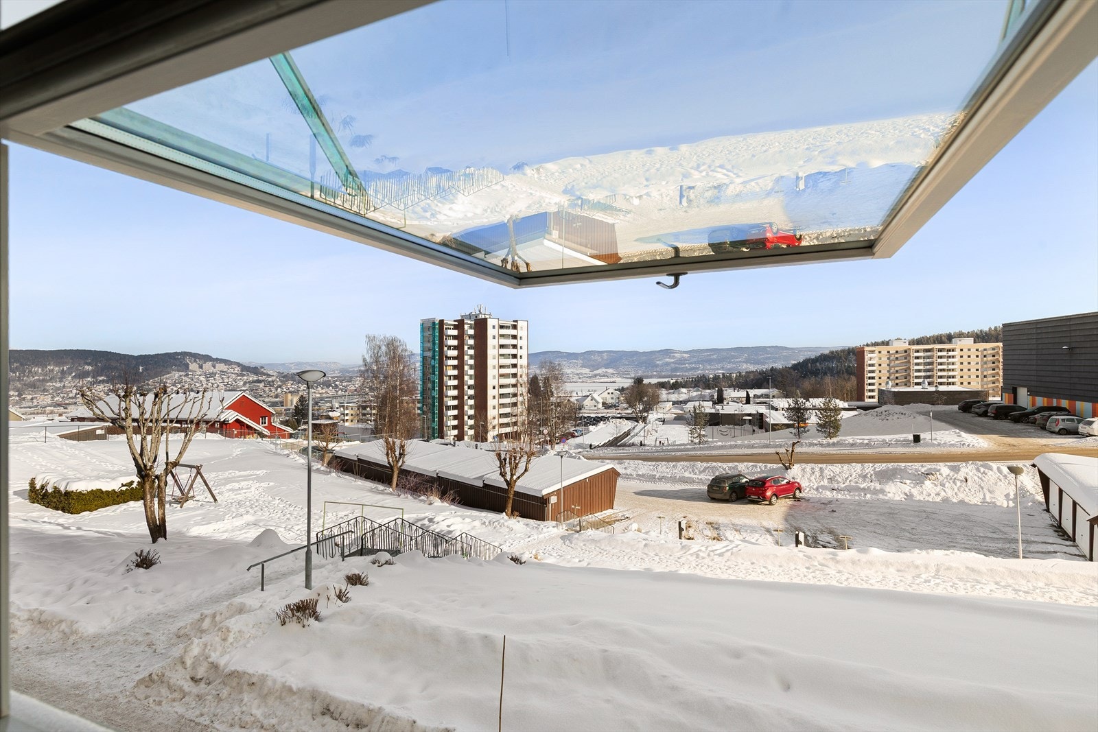 Utsikt mot parkeringsarealet tilhørende borettslaget, og videre ned mot fjorden Galleribilde