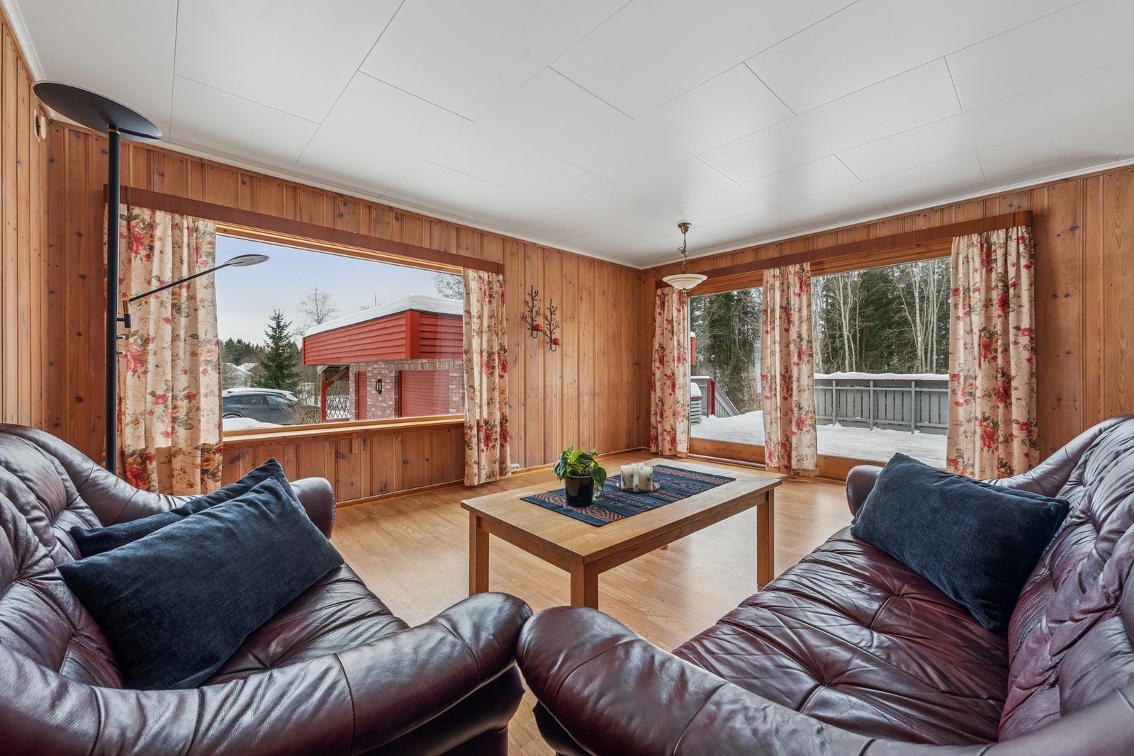 De varme trefargene på veggene skaper en lun atmosfære, mens rommets størrelse gir fleksibilitet for ulike møbleringsløsninger. Her er det god plass til både sofagruppe og egen sittekrok. Galleribilde