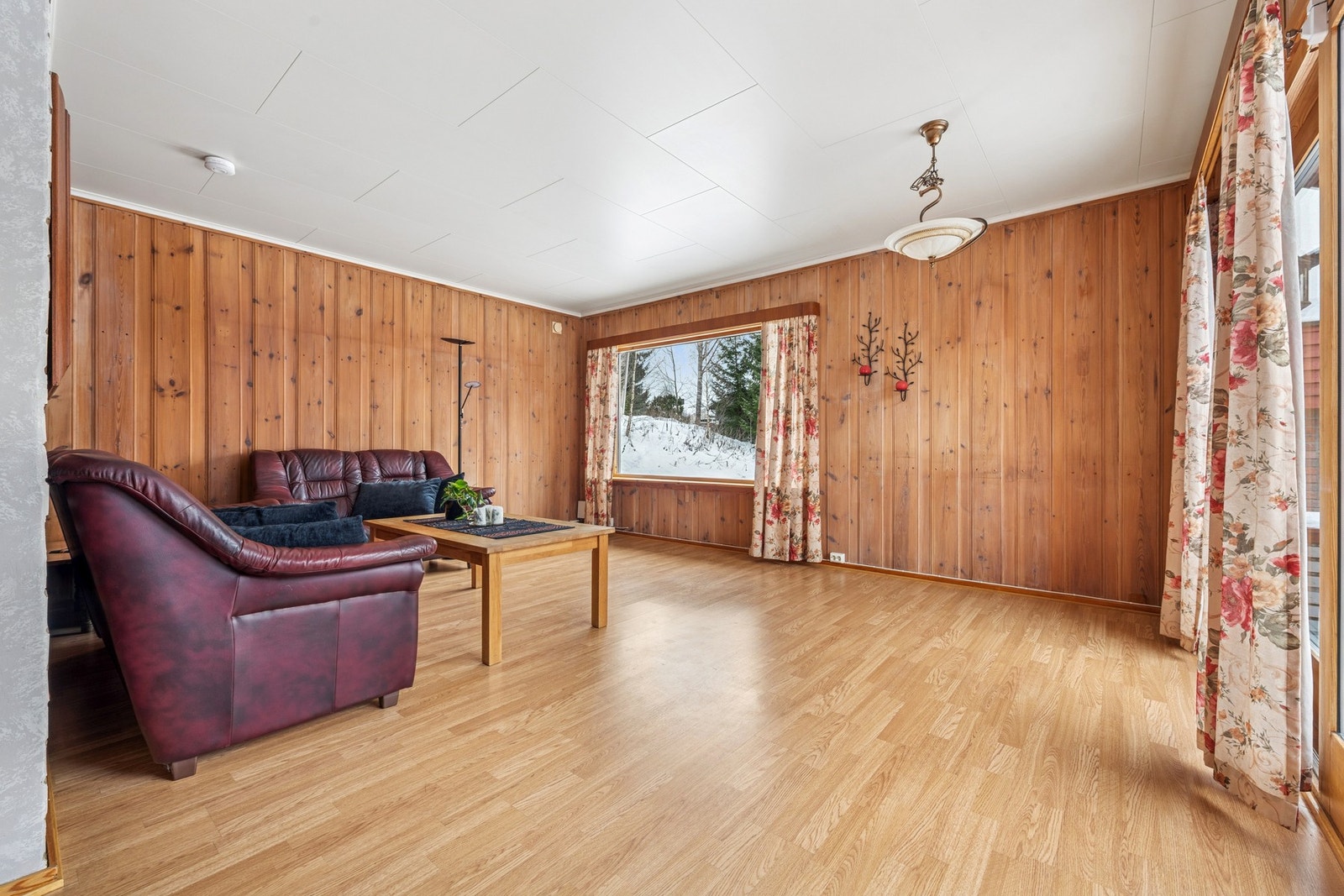 Stor og luftig stue med generøse vindusflater som slipper inn rikelig med dagslys og gir flott utsyn mot tomten. Galleribilde