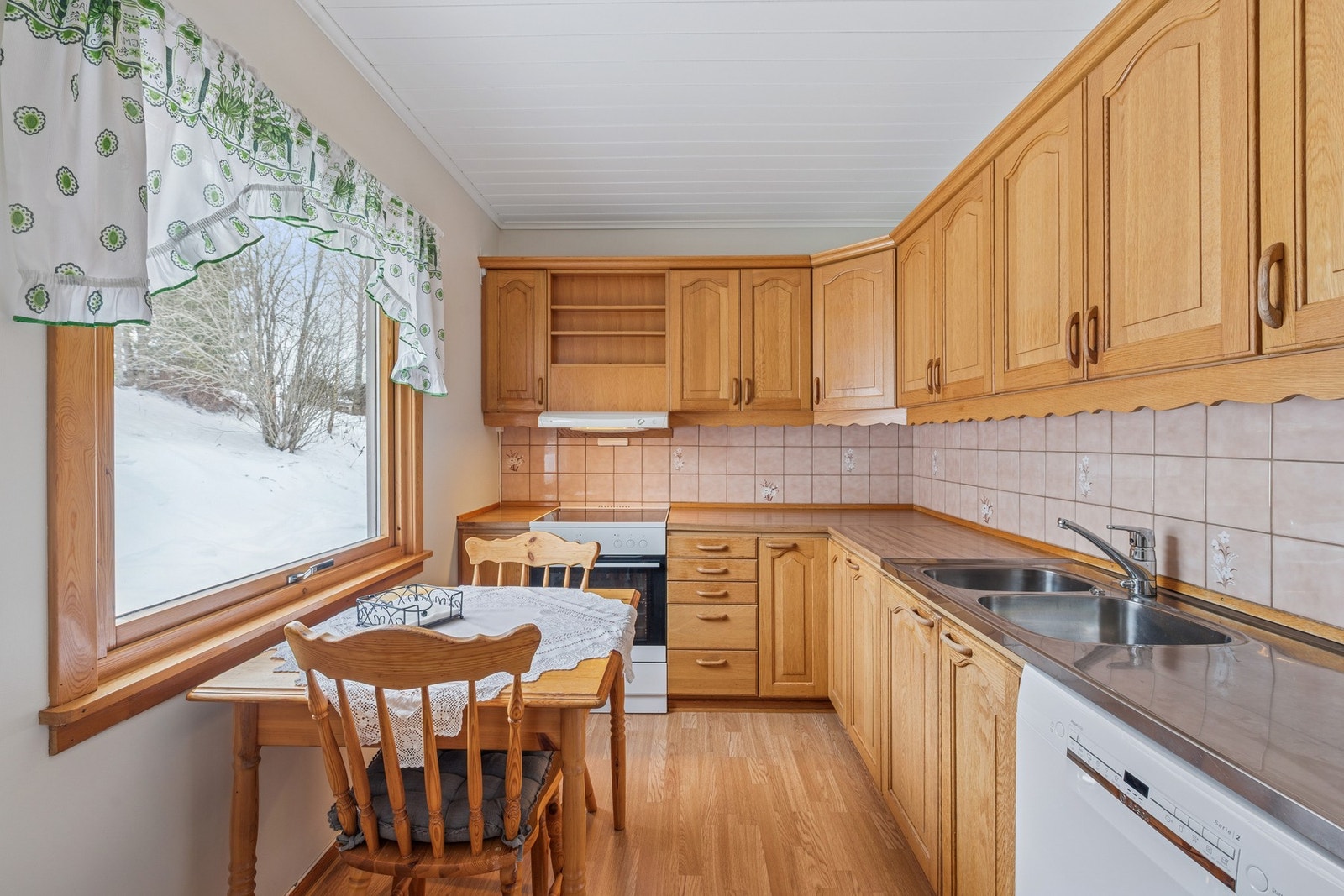 Pent og praktisk kjøkken med klassisk innredning i tre. Gode arbeidsflater og rikelig med skapplass gjør rommet effektivt i bruk. Galleribilde