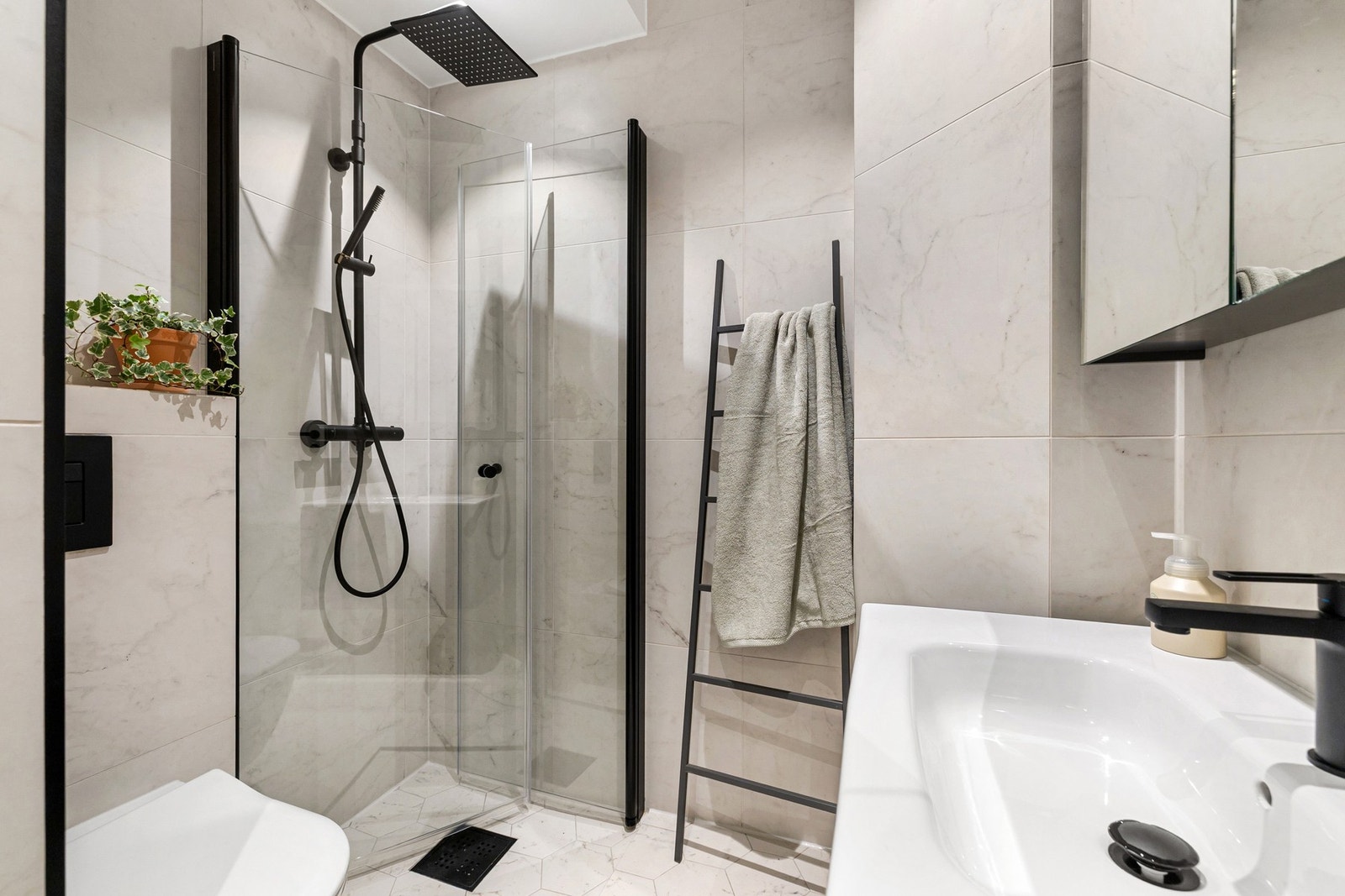 Baderomsinnredningen fremstår delikat og funksjonell, med blant annet innlagt stikkontakt i speilskap og servant. Galleribilde