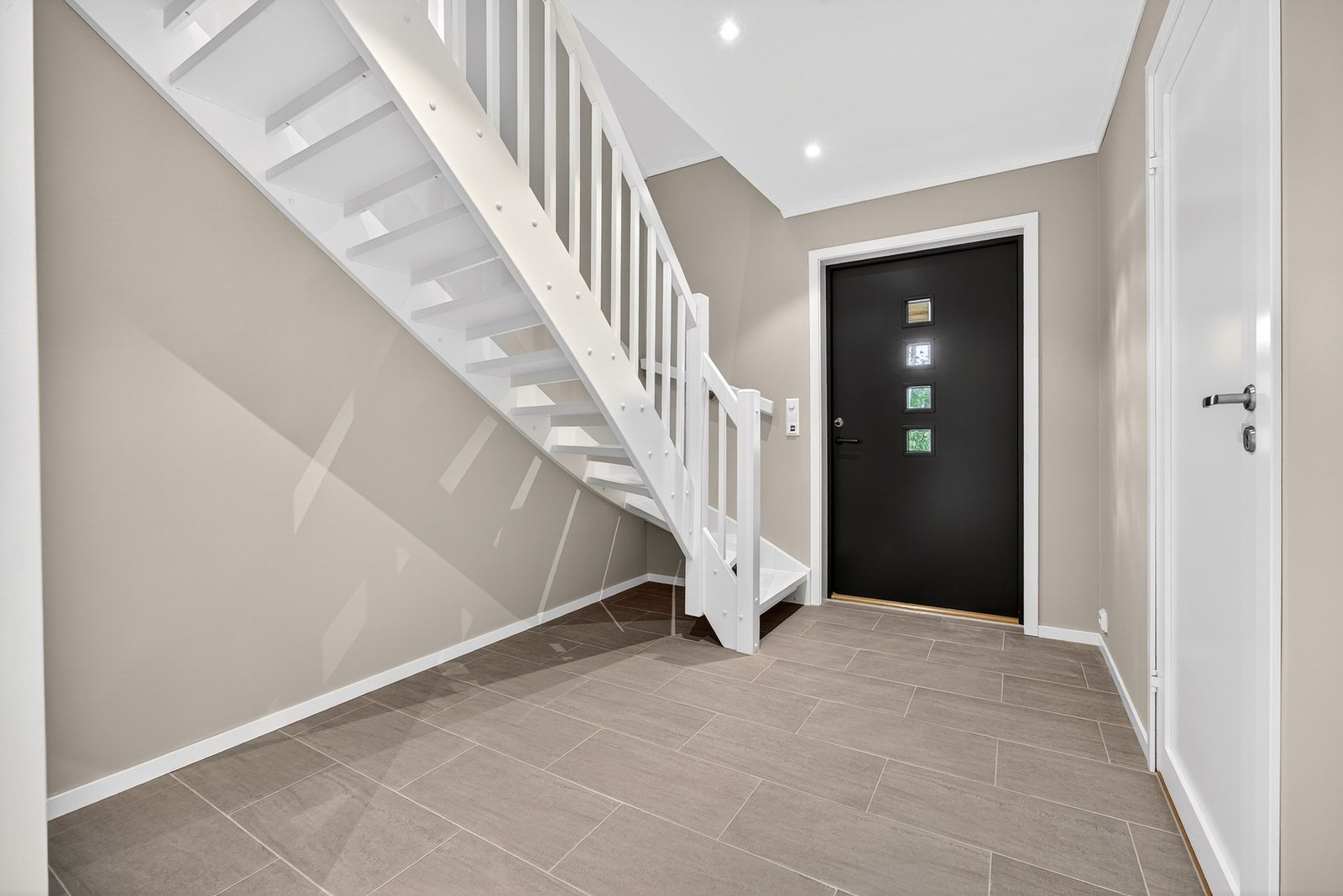 Entreen har fliser på gulv med gulvvarme, samt malte lyse overflater. Bilder er ikke av selve boligen, kun ment som illustrasjon. Galleribilde