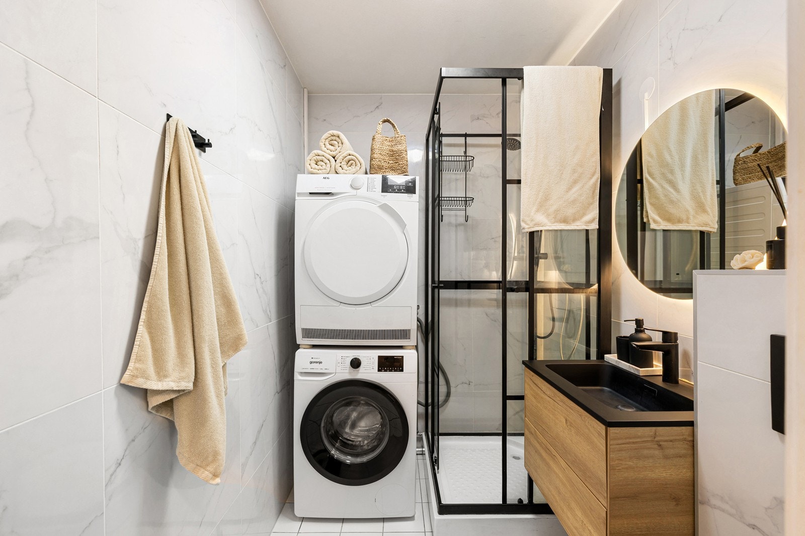 Stilrent bad med sorte detaljer, servantinnredning og plass til vask/tørk. Galleribilde