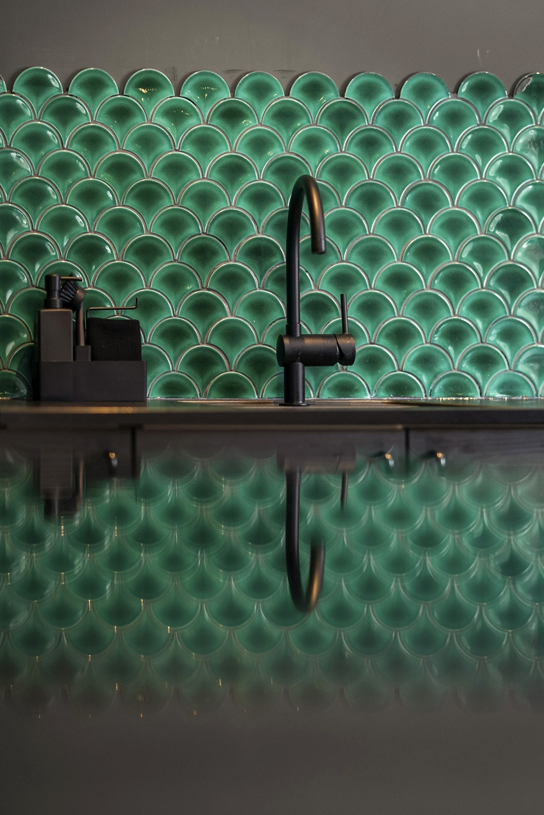 Dekorative fliser og sorte detaljer gir kjøkkenet et særpreget og moderne preg. Galleribilde