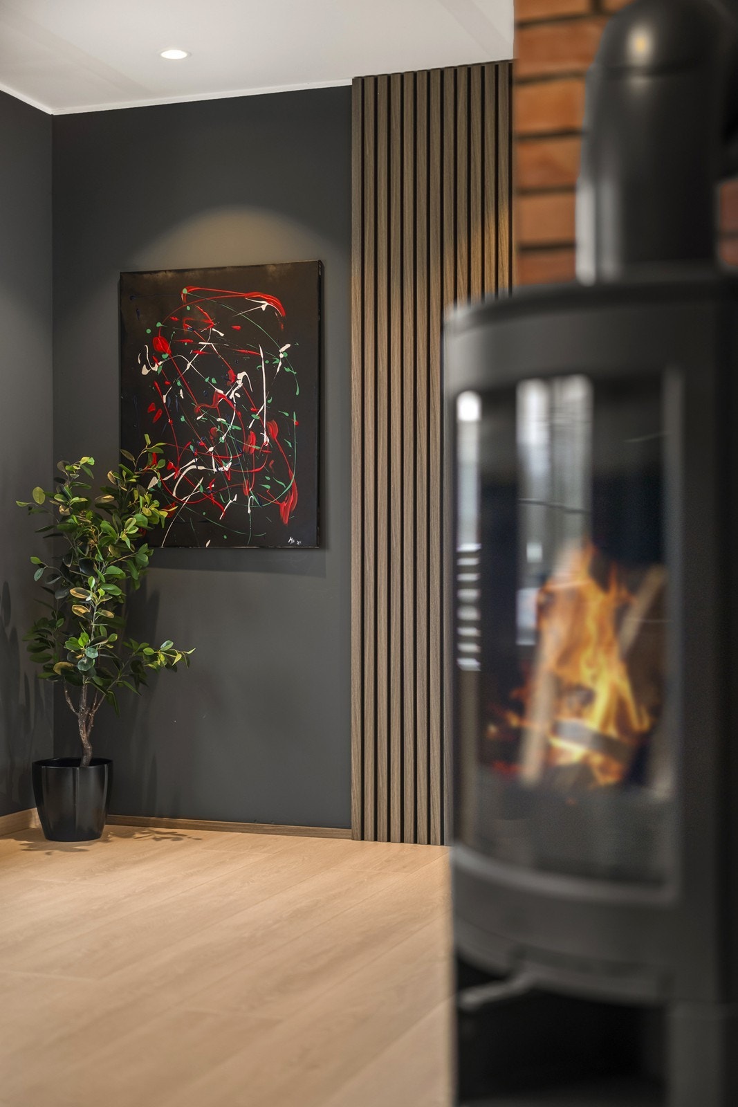 Kombinasjonen av spilevegg i tre og teglstein skaper en fin kontrast i stuen. Galleribilde