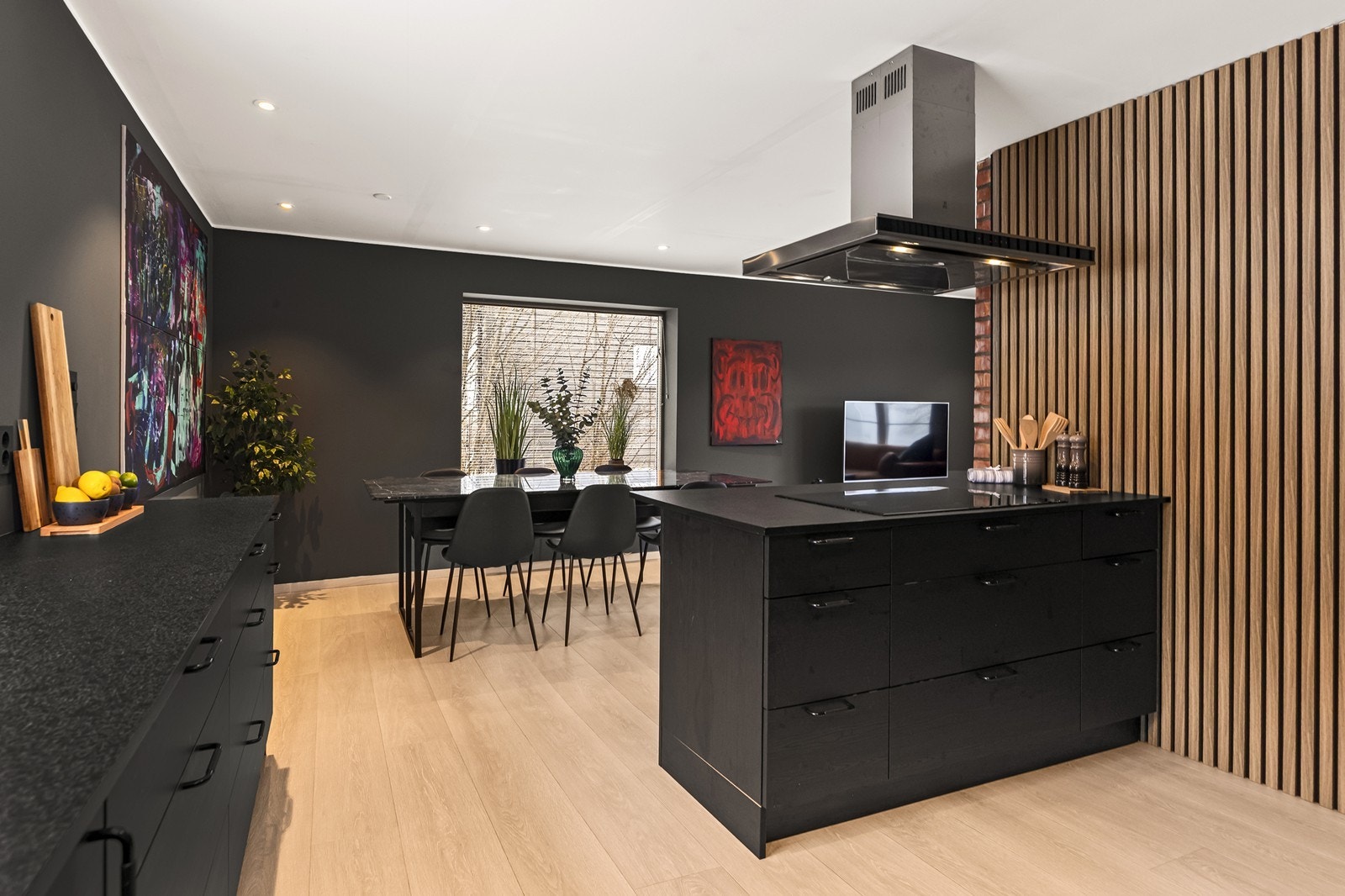 Kjøkkenøya med integrert induksjonstopp fungerer som et sosialt og praktisk midtpunkt - og skaper et naturlig skille ut mot stuen. Galleribilde