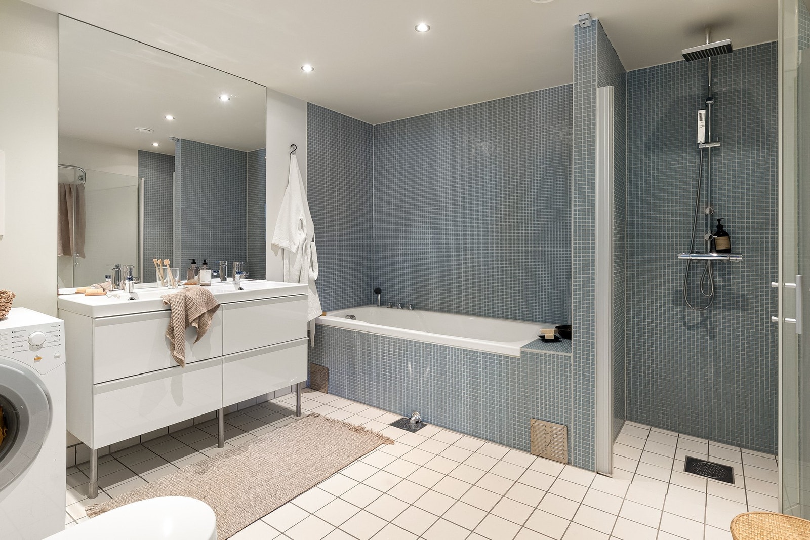 Innbydende flislagt baderom (fra leilighetens byggeår, 2011) med termostatstyrte varmekabler i gulv og opplegg for vaskemaskin. Galleribilde