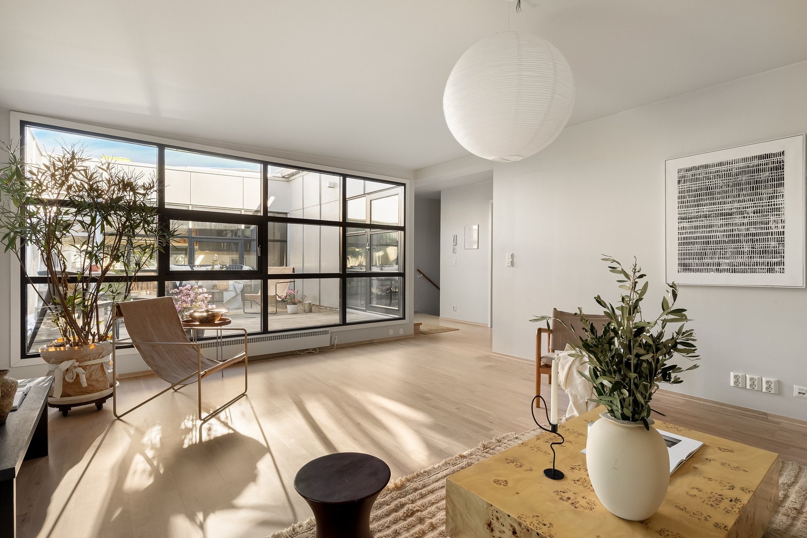 Terrassen er et flott skue på både dag- og kveldstid, omringet av stuen, gangen og kjøkkenet er uteplassen hjertet i leiligheten. Galleribilde