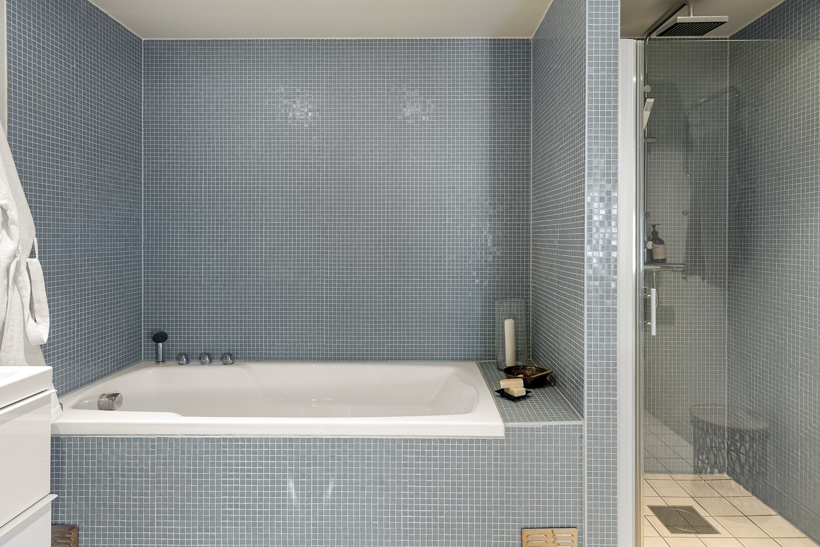 Baderommet inneholder både stort og fint badekar og dusjhjørne med svingdør av herdet glass, sluk, regnfallsdusj og termostatstyrt blandebatteri. Galleribilde