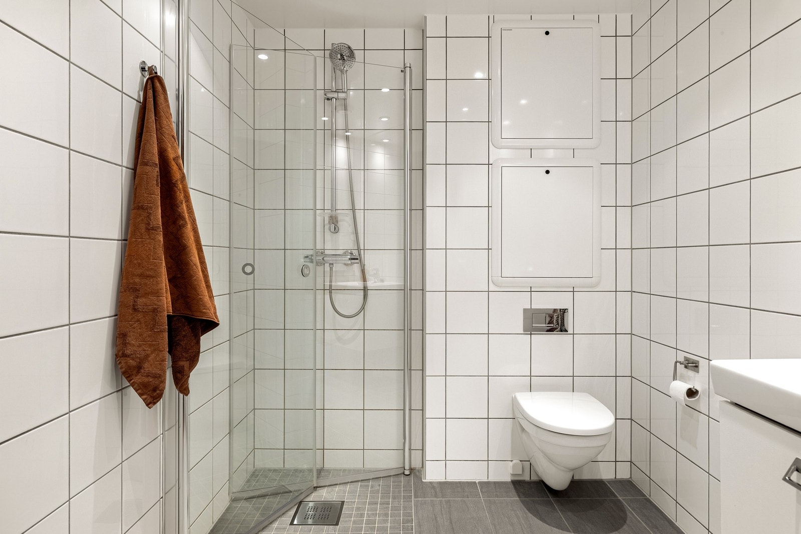 Delikat, helfliset bad på 3,9 kvm med moderne uttrykk. Himlingen har hvitlakkerte aluminiumsplater med innfelte downlights som gir behagelig belysning. Galleribilde