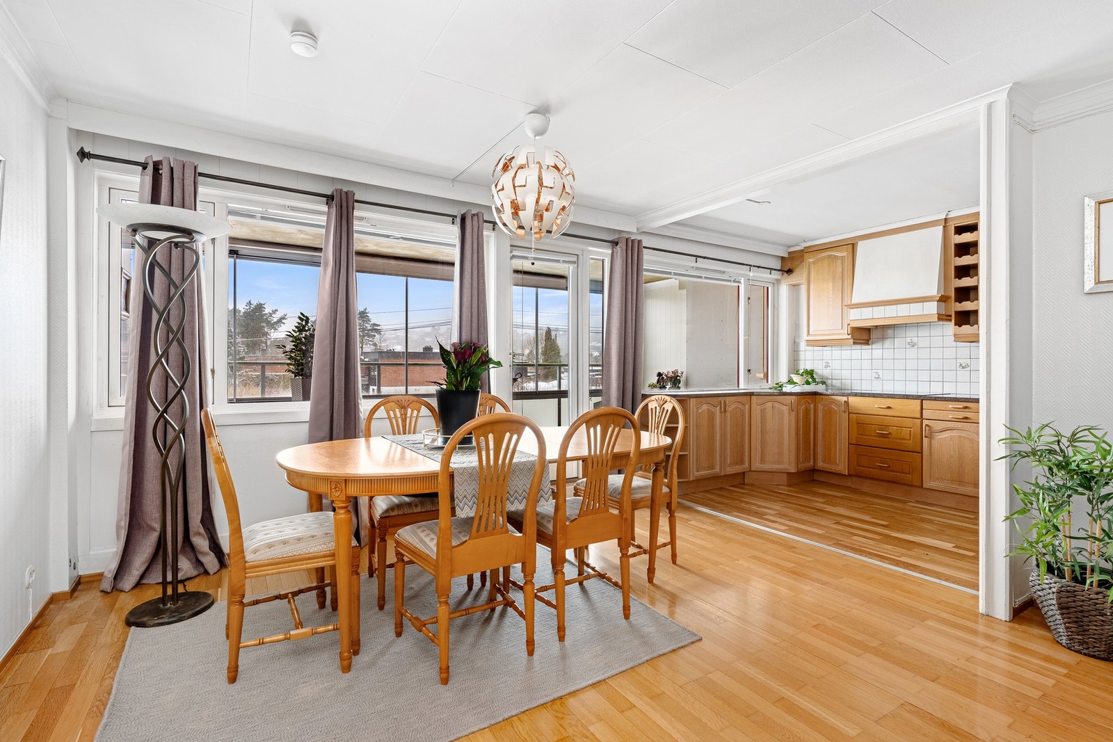 Spisestue med delvis åpen kjøkkenløsning og utgang til vestvendt balkong Galleribilde