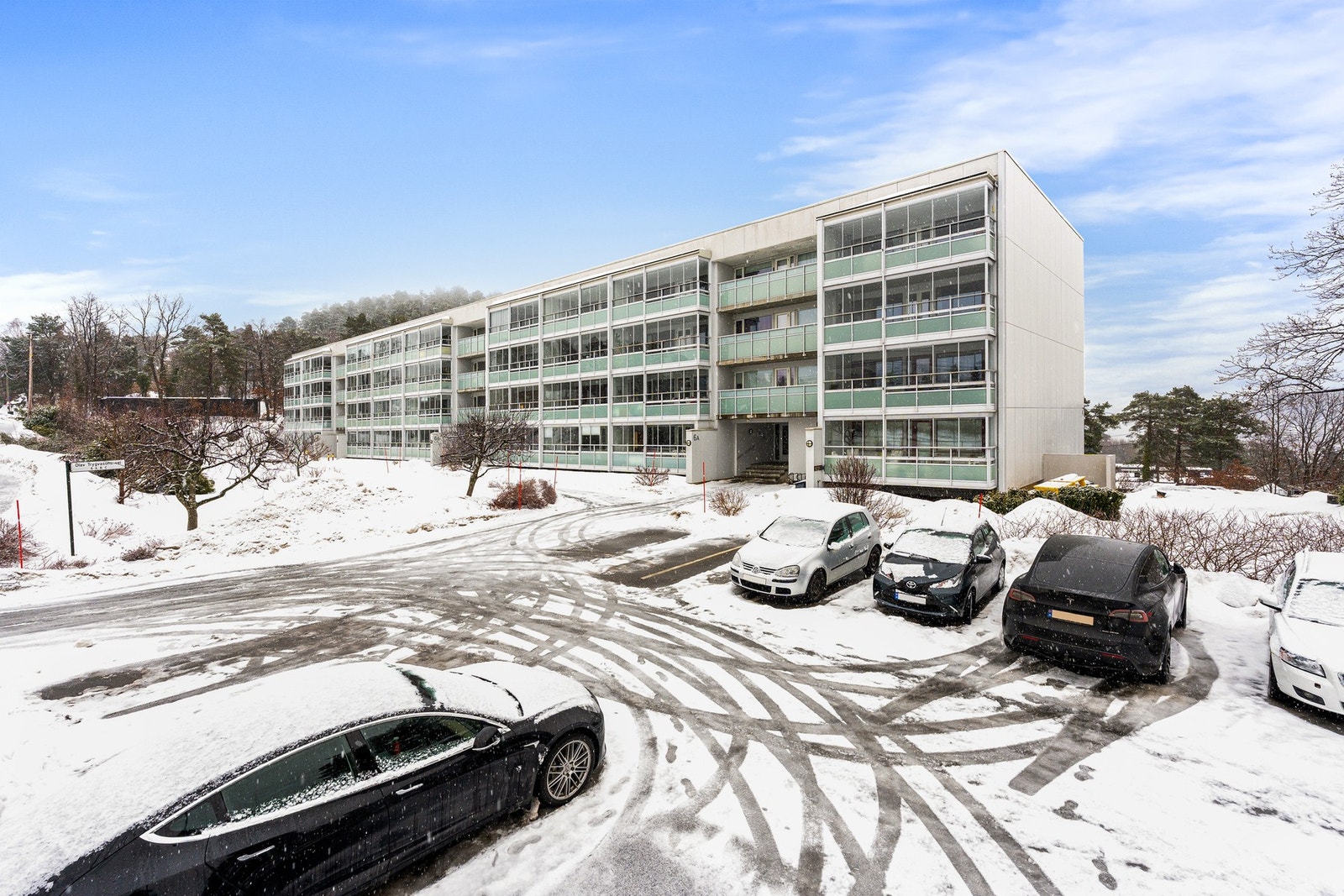 Blokkas fasade med parkeringsplasser i front Galleribilde