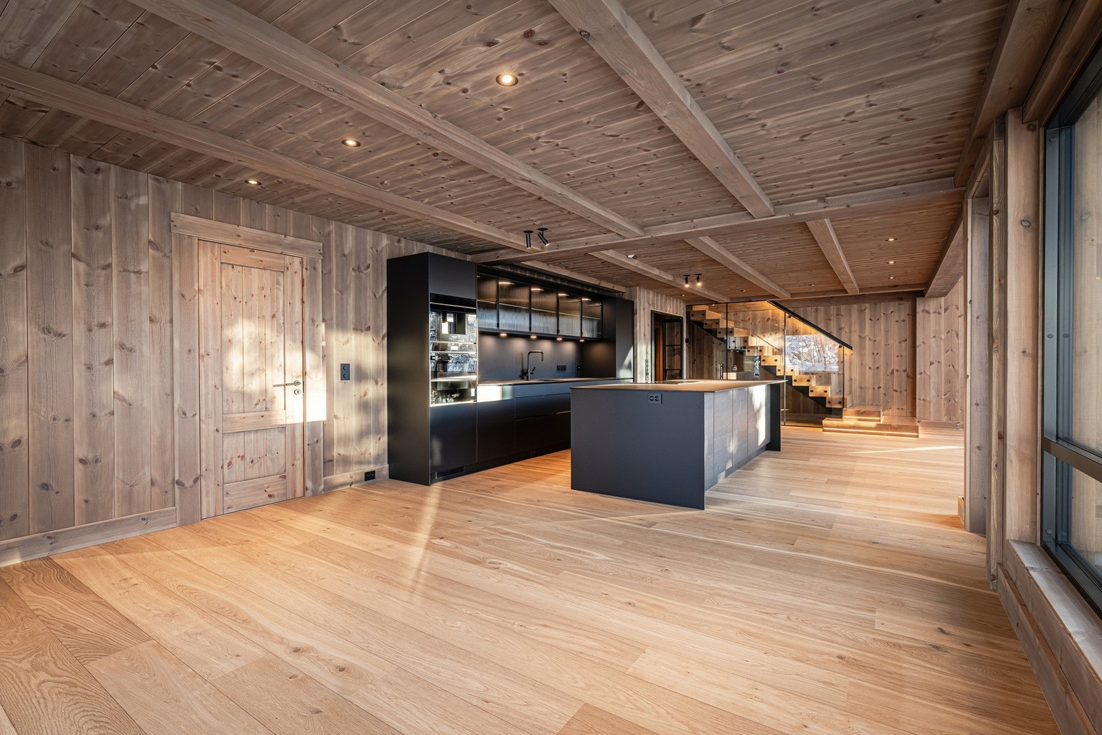 Lekkert kjøkken i dempet grå tone, med romslig kjøkkenøy og åpen, sosial planløsning. Galleribilde