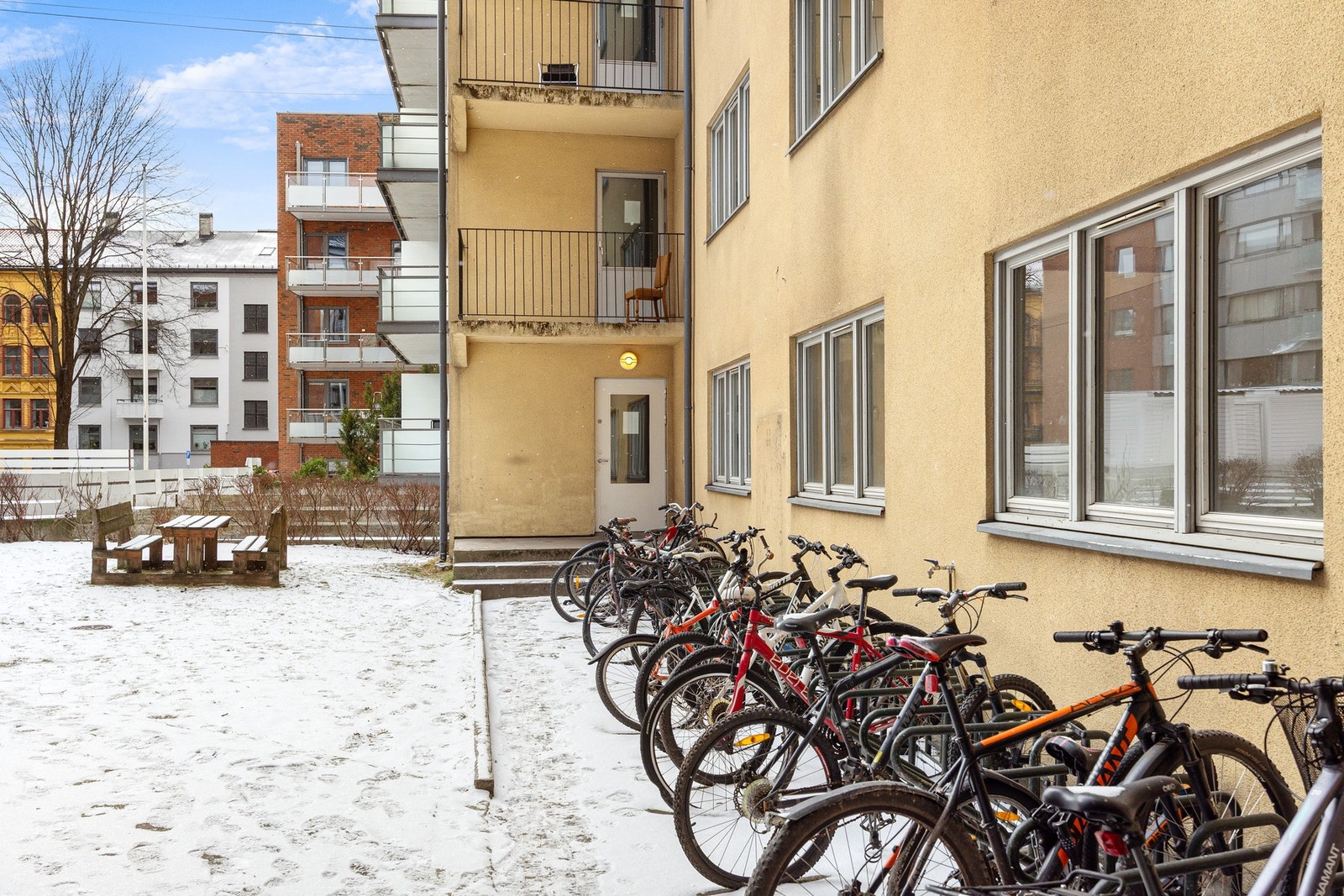 Bakgården er pent opparbeidet med sittebenk, gressplen, beplantning, og sykkelparkering. Galleribilde