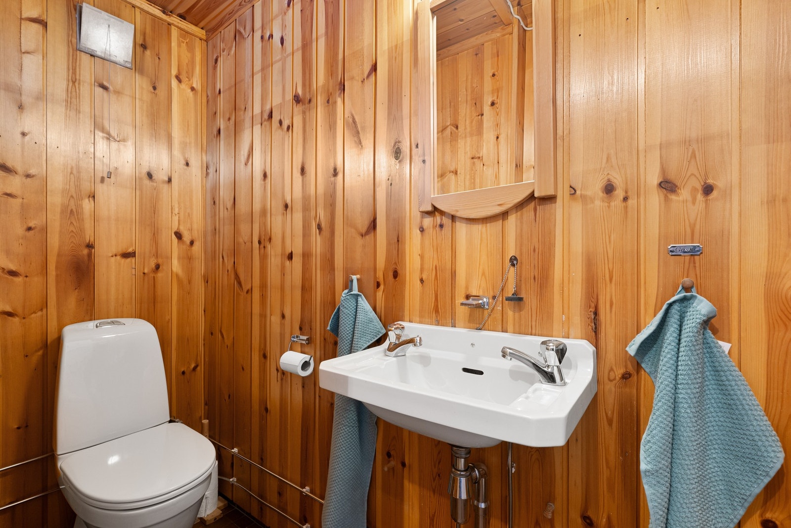 Separat toalettrom i hovedetasjen med adkomst fra vindfang. Rommet har panel på vegger, servant og toalett. Galleribilde