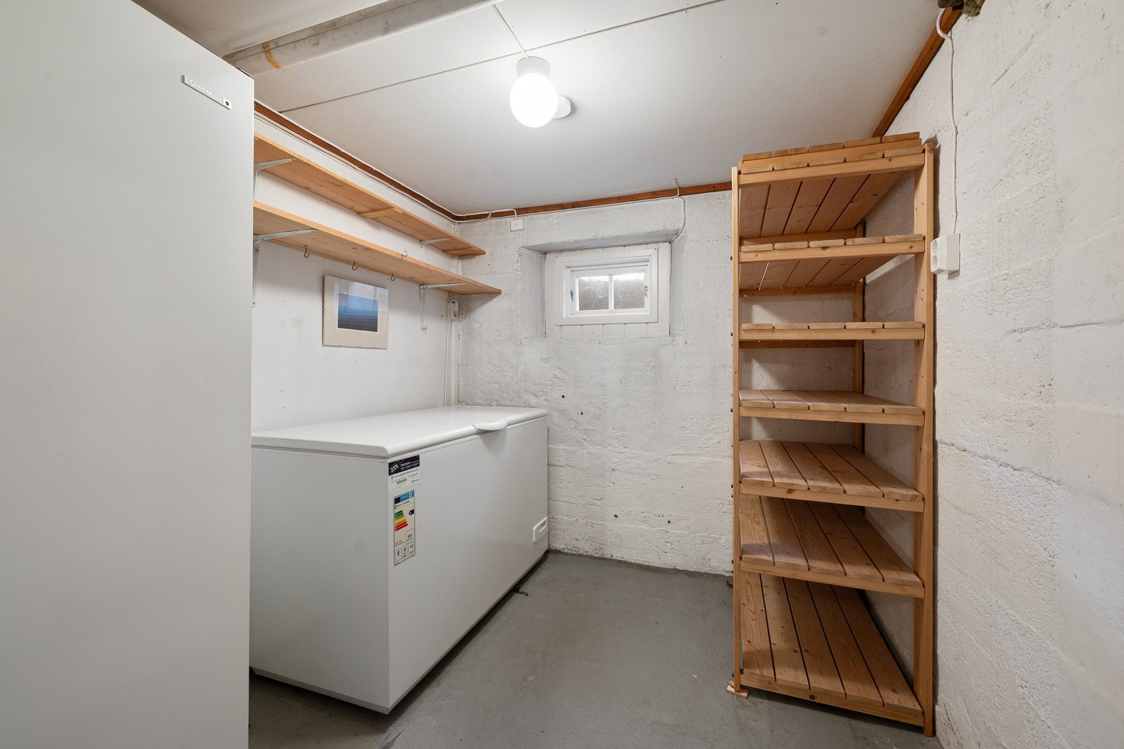 Eget lagringsrom med plass til fryser og hyller langs veggene, ideelt for ekstra oppbevaring og organisering. Galleribilde
