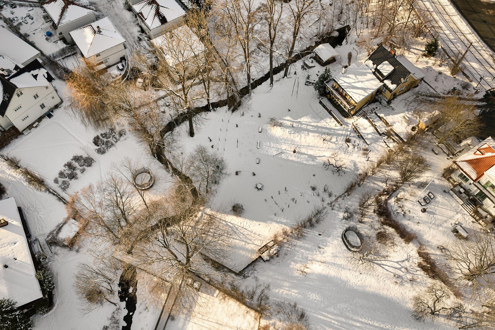 Fra luften ser man hvordan eiendommen strekker seg langs Mærradalsbekken, med hage, trær og naturlige soner for lek og opphold. Galleribilde