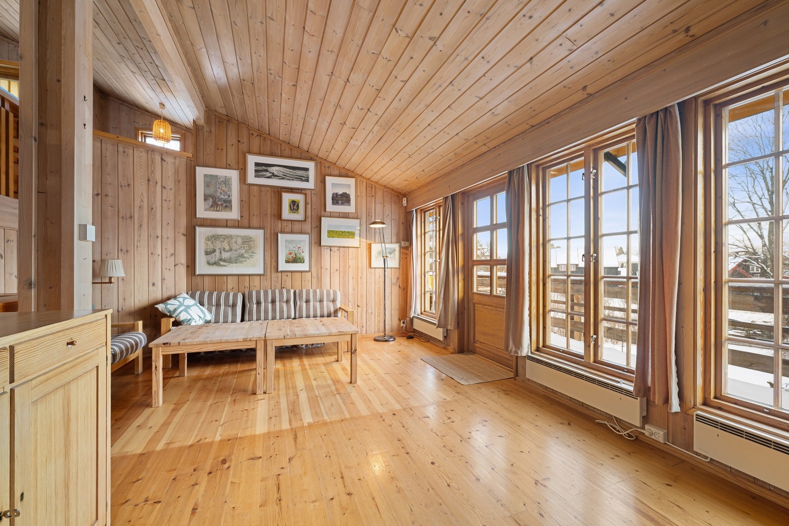 Romslig stue med store vindusflater og utgang til balkong, som slipper inn rikelig med lys og gir utsyn mot hagen. Galleribilde