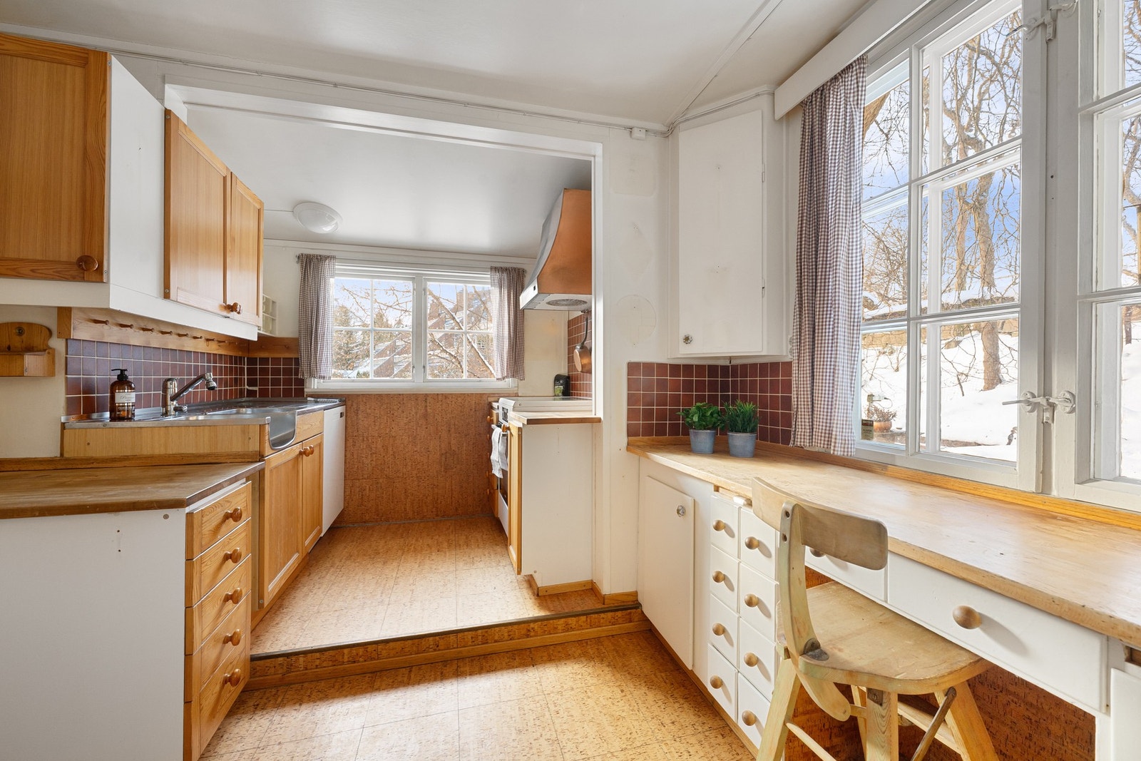 Kjøkken med profilerte fronter og heltre benkeplate, samt integrert arbeidsplass ved vinduet med utsikt mot hagen. Rommet har en funksjonell planløsning og gode muligheter for modernisering etter eget ønske. Galleribilde