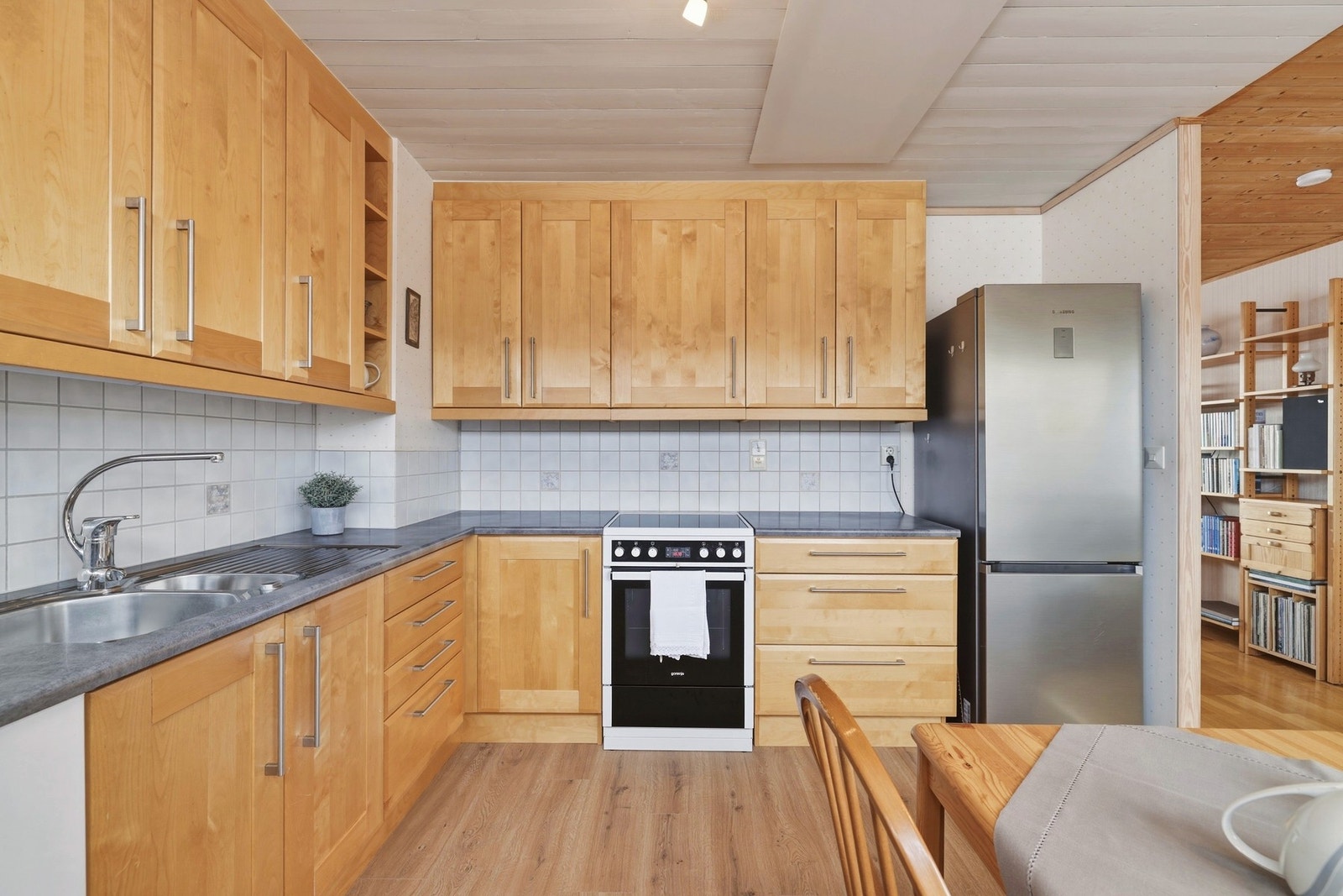 Kjøkkeninnredningen fra Mørekjøkken (2006) har profilerte bjørkefronter og takhøy løsning som gir godt med oppbevaringsplass. Galleribilde