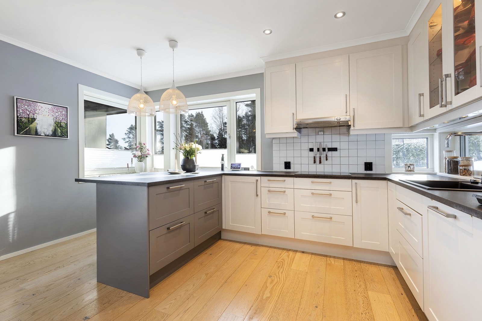 Kjøkkenet er oppgradert med ny vask og benkeplate samt praktisk kjøkkenøy med sitteplasser og skap som matcher innredningen forøvrig, og de gråmalte veggene. Galleribilde