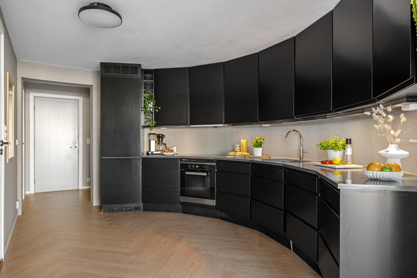 Stilren kjøkkeninnredning fra Huseby, installert i 2014. Kjøkkenet har et sømløst uttrykk med integrert oppvaskmaskin, kjøl/fryseskap, stekeovn og induksjon platetopp. Galleribilde