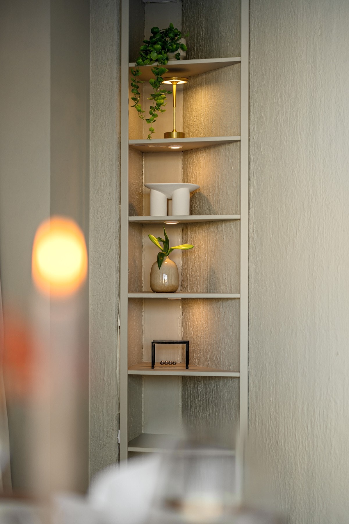 Den plassbygde hylleseksjonen smelter sømløst inn i rommet og gir stuen et gjennomført og eksklusivt uttrykk. Her er det god plass til både bøker, kunst og personlige favoritter. Galleribilde