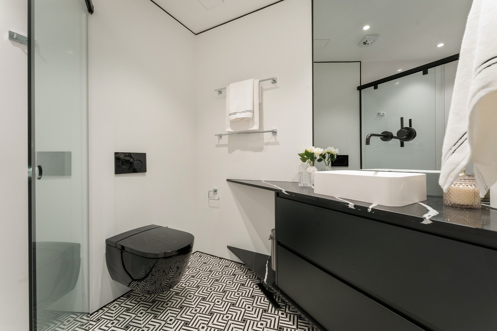 Det andre baderommet ble etablert i 2023 og fremstår mer grafisk og moderne med mørk innredning og romslig dusjplass med stor regnfallsdusj. Galleribilde