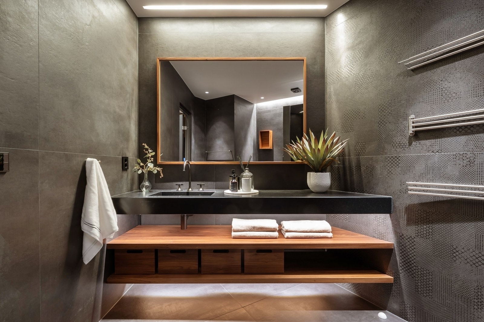 Hovedbadet, oppgradert i 2021, fremstår som et elegant og spa-inspirert rom med flislagte overflater, valnøttdetaljer og en sober, eksklusiv materialitet. Galleribilde