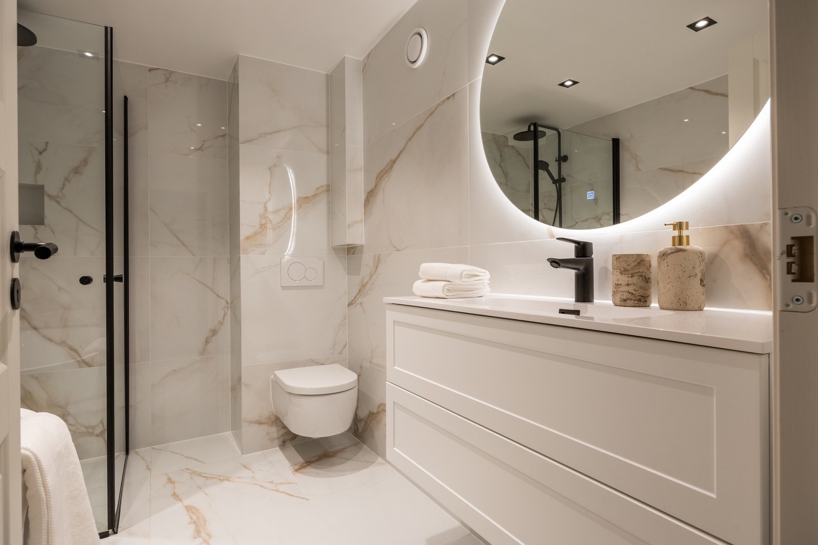 Lekkert baderom fra 2026 med flislagt gulv med varme og flislagte vegger. Galleribilde