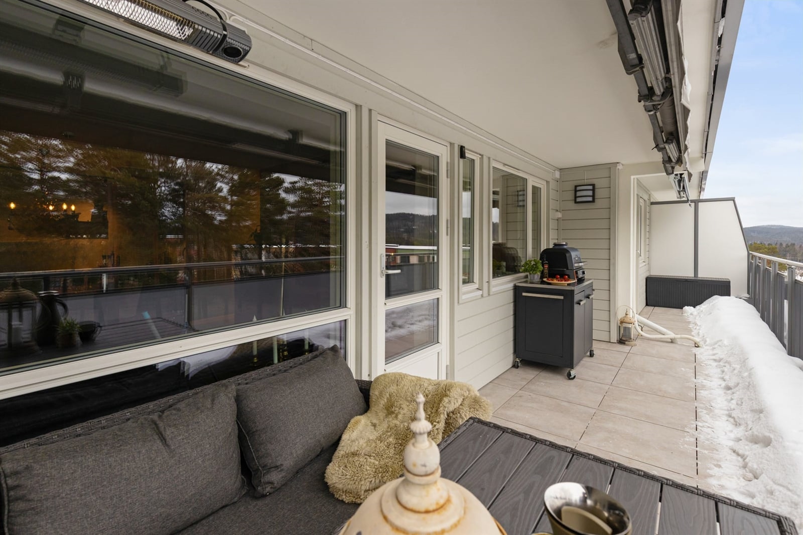 Balkongen har god plass til en utendørs sittegruppe for sosiale anledninger. Balkongdekket har fliser, noe som gir et solid og vedlikeholdsvennlig underlag. Galleribilde