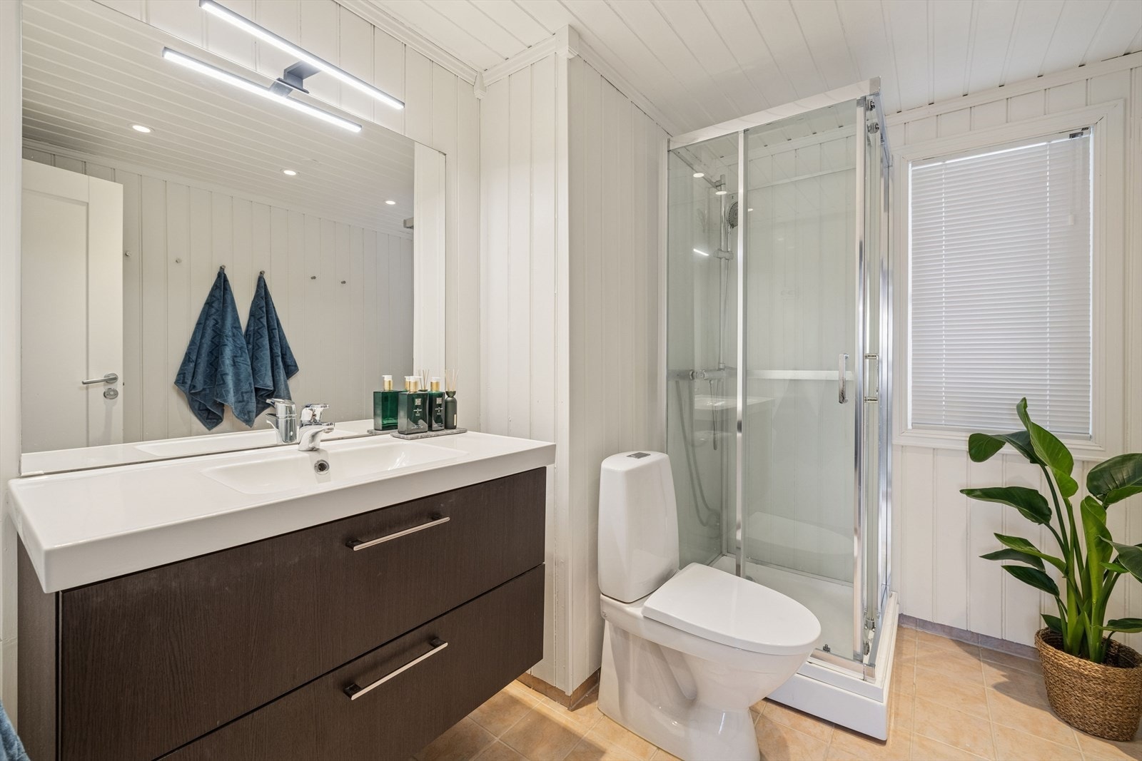 Bad med fliser på gulv, malt panel på vegger. Galleribilde