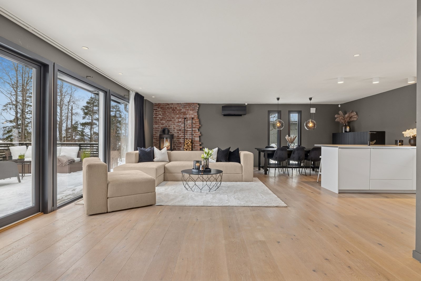 Stor, åpen stue- og kjøkkenløsning med gjennomgående enstavs parkettgulv og store vindusflater. Lun og effektiv peisovn (2022) og varmepumpe (2024). Galleribilde