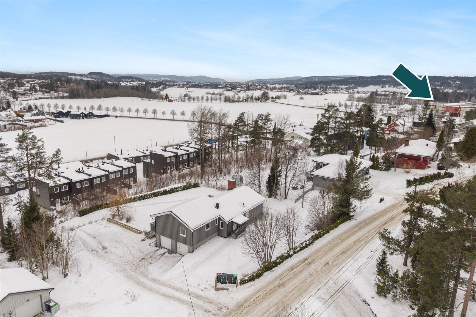 Høyt og frittliggende enebolig beliggende i meget barnevennlig omgivelser med barneskolen i umiddelbar nærhet (pilen viser barneskolen). Galleribilde