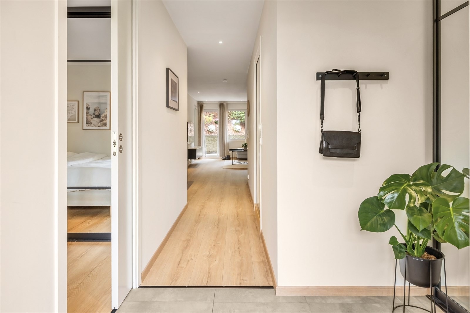 Romslig entré med fliser på gulv og stor praktisk skyvedørsgarderobe med opplegg for sko og ytterklær. Galleribilde