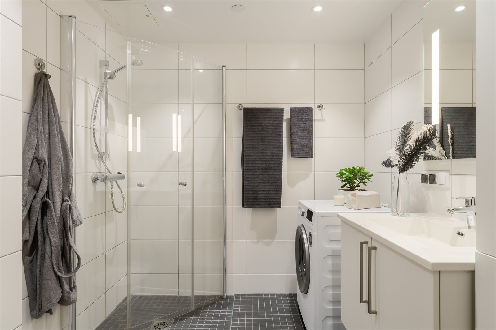 Badet er på ca. 5m² og har flislagt gulv og vegger, servant, dushjørne og opplegg for vaskemaskin! Galleribilde